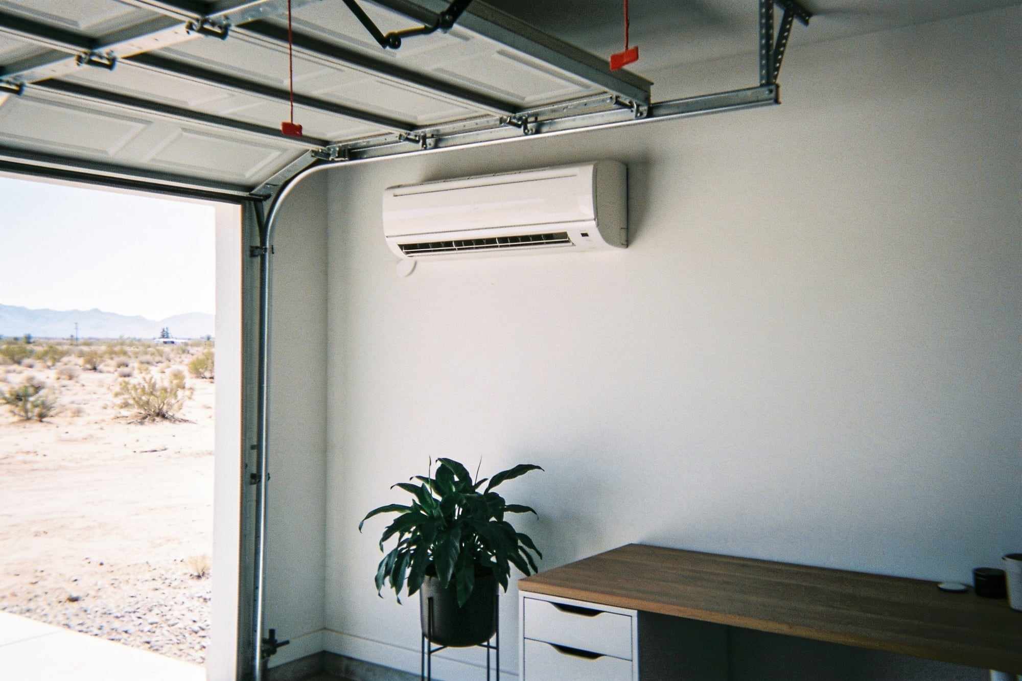 A slim white mini-split unit on the wall of a bright home office